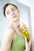 Young woman spraying herself with perfume