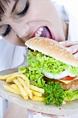 Young woman biting into a hamburger
