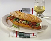 Baguette roll filled with salami, dried tomatoes & rocket