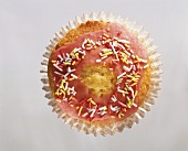 Muffin mit rosa Glasur und Zuckerstreusel