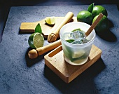 Limes and ice cubes in a glass with a pestle