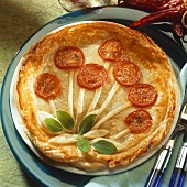 Pie decorated with tomato slices and sage