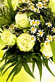 Arrangement of white roses, chamomile flowers and grasses