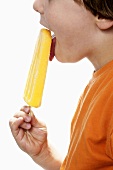 Boy enjoying an orange ice lolly