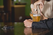 Man and woman at a bar with beer and wine, car keys