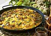 Paella (rice dish) with meat, vegetables and snails