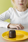 Girl looking at chocolate teacake on plate