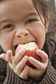 Girl biting into an organic apple