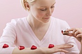 Young woman with red chocolate hearts on her arm