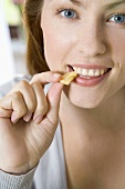 Young woman eating a piece of croissant