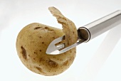 Potato with potato peeler