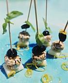 Soft cheese & olives with sesame & basil on cocktail sticks