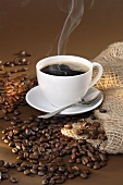 Steaming black coffee and coffee beans
