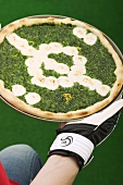 Spinach pizza representing football pitch