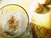 Café latte with milk foam and almond biscuits on book