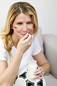 Young woman with football eating natural yoghurt