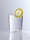 A glass of water with a slice of lemon