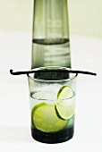 Mineral water with lime slices, ice cubes and vanilla pod