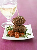 Two meatballs on tomato with herbs