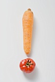 One carrot and one tomato forming an exclamation mark