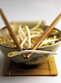 Small bowl of soya sprouts with chopsticks