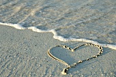 Heart drawn in the sand by the sea