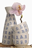 Sake flask (choshi) and cups (sakazuki) with orchid