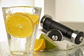 Mineral water with slice of lemon and hand weights
