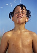 Boy spitting out water while bathing