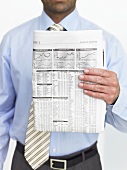 Mann zeigt die Börsenkurse in der Zeitung
