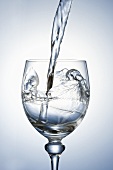 Wasser in Stielglas eingiessen