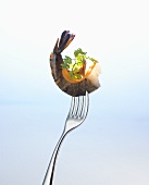 Prawn with parsley and sliver of carrot on a fork