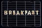 Toast letters spelling the word BREAKFAST on a rack