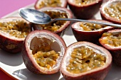 Halved passion fruits with spoon