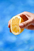 A hand squeezing a lemon