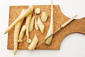 Fresh White Carrots on a Cutting Board with Knife; Whole and Chopped