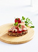 A slice of wholemeal bread with tomatoes and ham