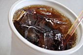 Cola in a plastic cup with ice
