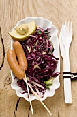Red cabbage salad with sausages, mustard and sliced apple