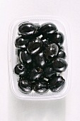 Entsteinte schwarze Oliven in einer Platikschale
