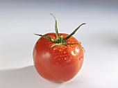 A tomato with drops of water