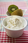 Cottage cheese in a small bowl, kiwi fruit behind