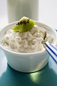 Cottage cheese with kiwi fruit and spoon in a small bowl