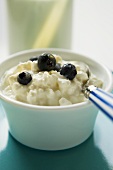 Cottage cheese with blueberries and spoon in a small bowl