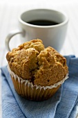 Muffin in front of a cup of coffee