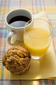 Coffee, orange juice and muffin on a fabric napkin