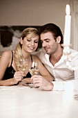Young couple clinking glasses of white wine