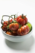 Red and green beefsteak tomatoes in a bowl