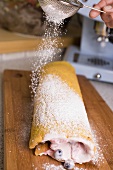 Sprinkling sponge roulade with icing sugar