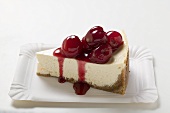 A piece of cheesecake with cherry sauce